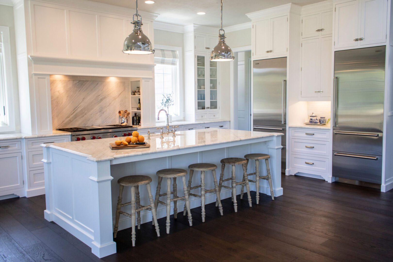 Modern kitchen with island seating and pendant lights.